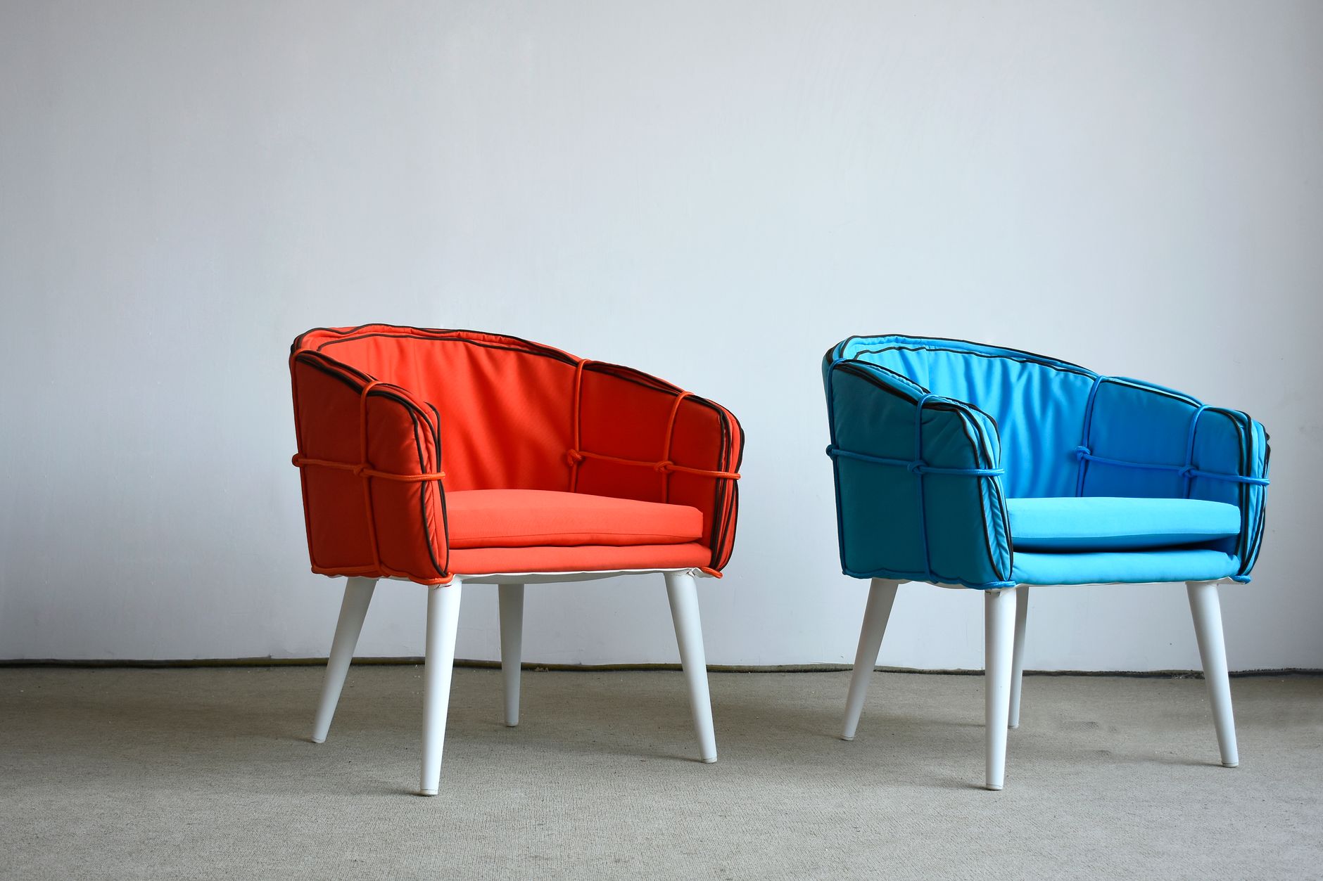 Modern orange and blue chairs against a minima