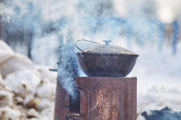 Cast iron pot on a smoky outdoor stove in a wi